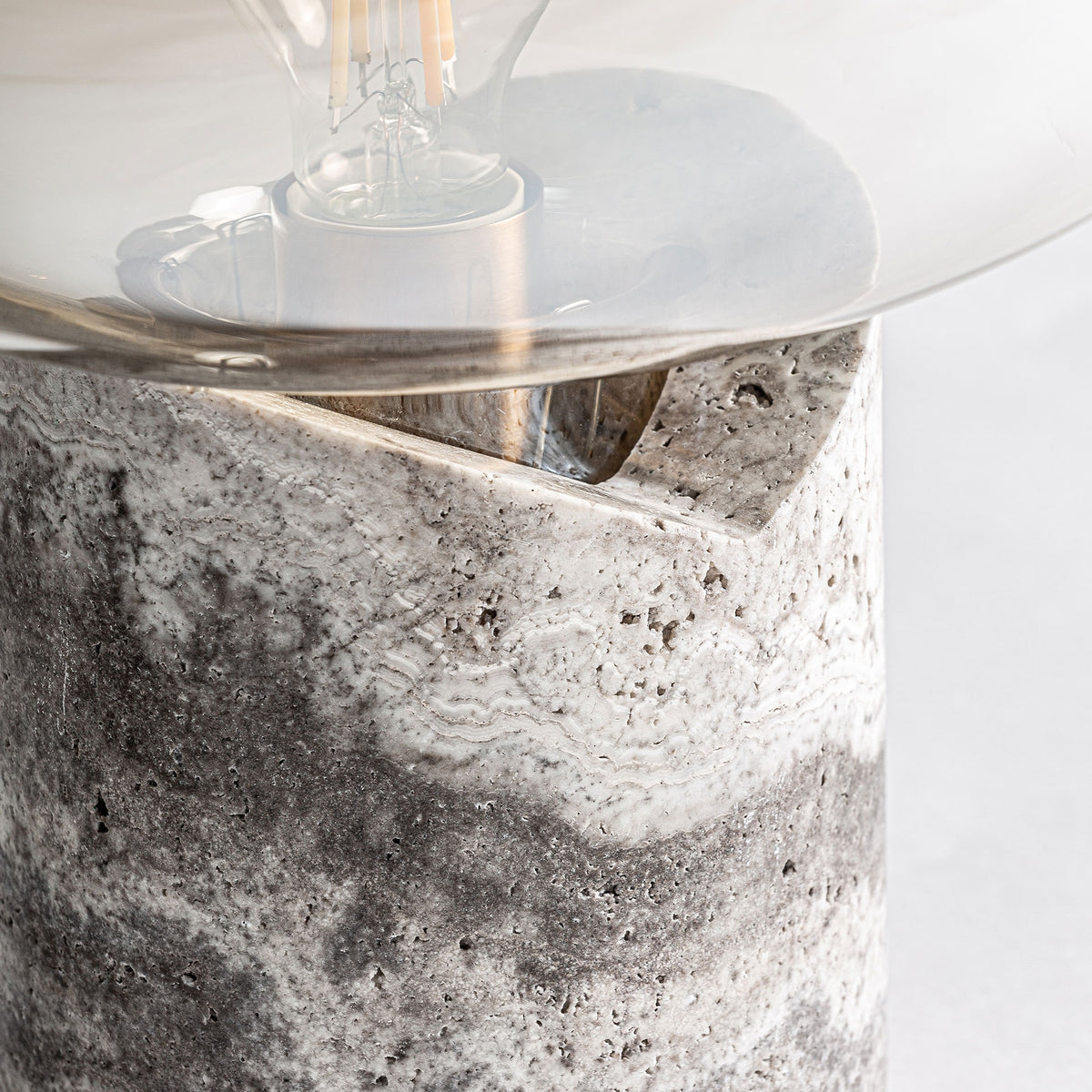 Detalle de la base de mármol gris y la pantalla de cristal de la lámpara Dumo