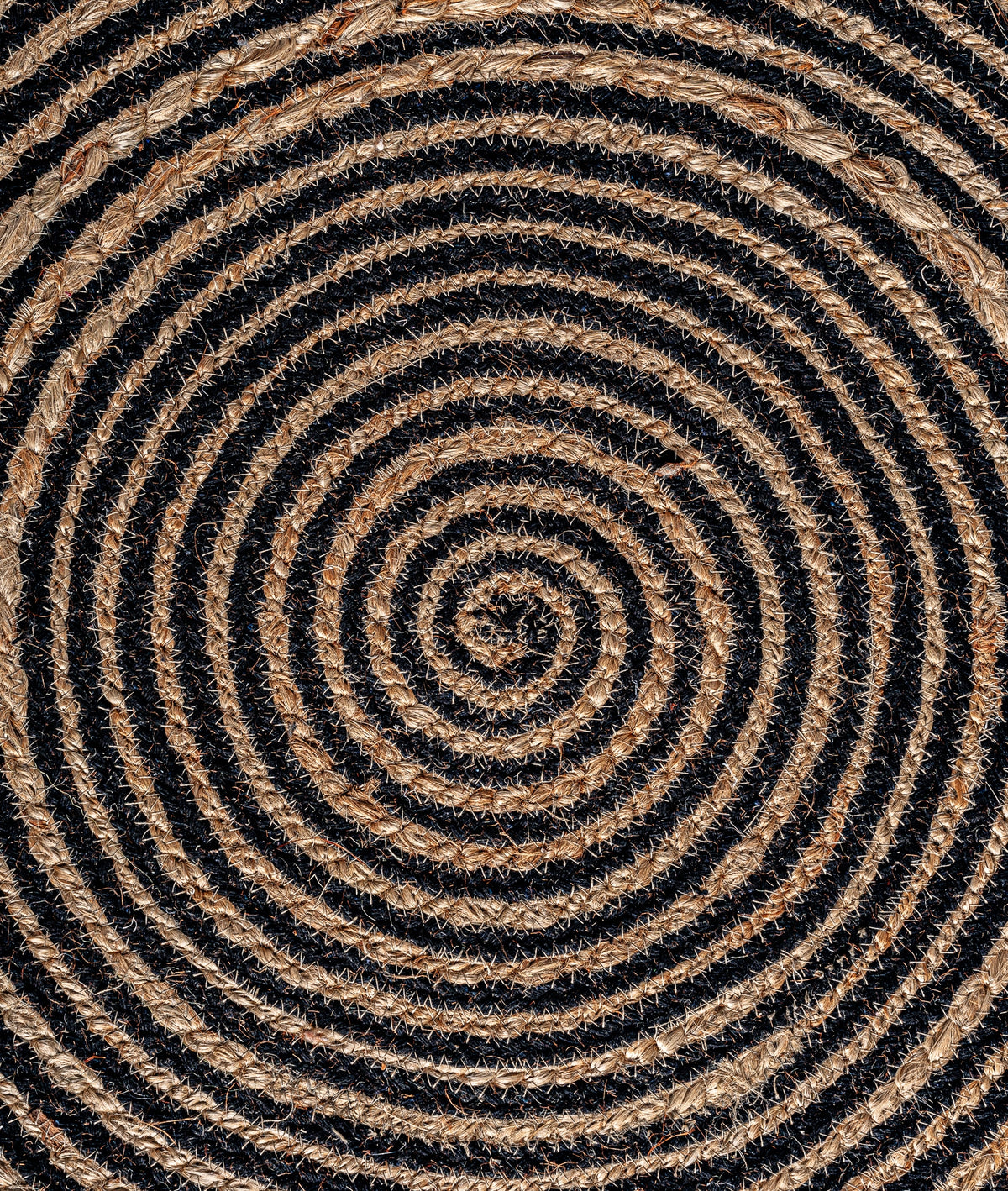 Detalle del trenzado en espiral beige y negro de la alfombra Leandra Kodu