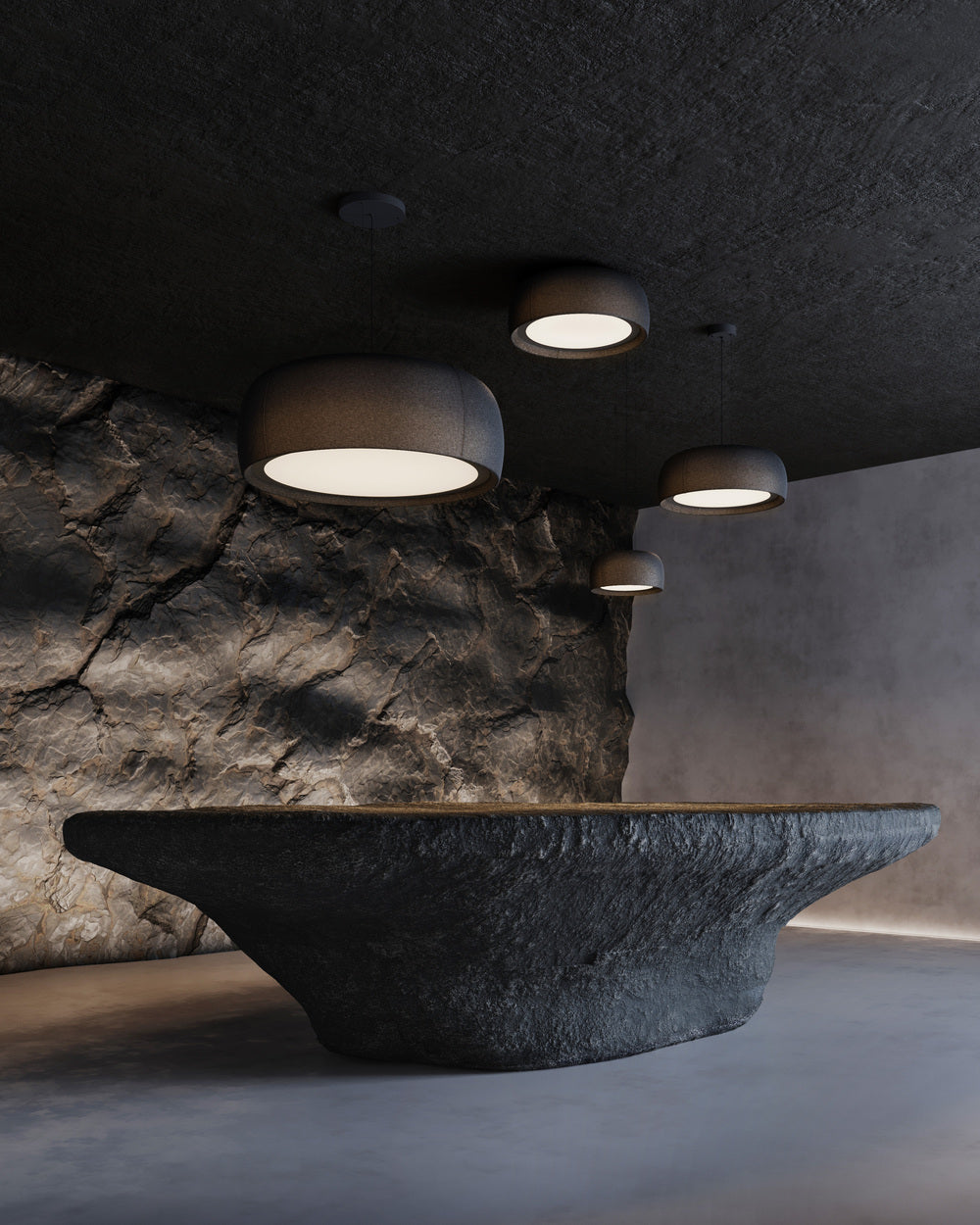 Ambiente oficial de la colección Gong de LEDS C4 en tonos oscuros, con plafones y luminarias colgantes de distintos tamaños junto a una pared de piedra