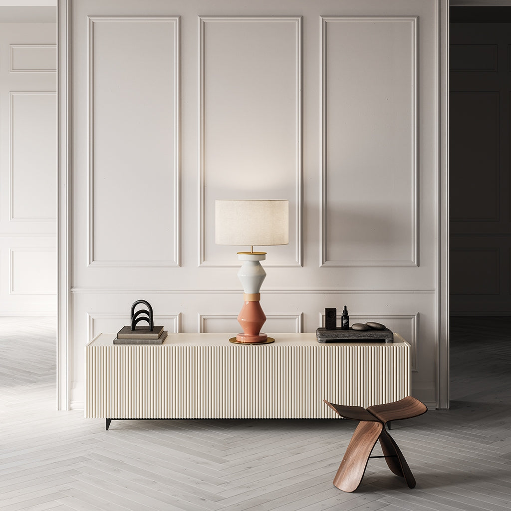 Lámpara de sobremesa Kitta Kitta en salón de diseño sobre aparador estriado