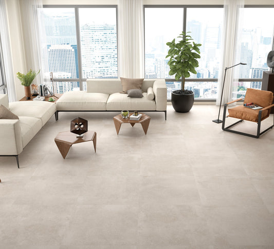 KTL Claire Arena 60x60 cm en salón con sofá, sillones y mesas de centro, suelo porcelánico efecto cemento